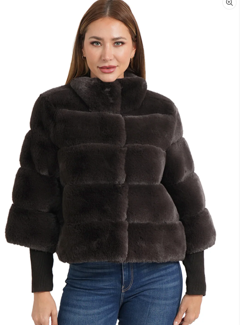 Woman wearing a dark brown faux fur jacket on a white background