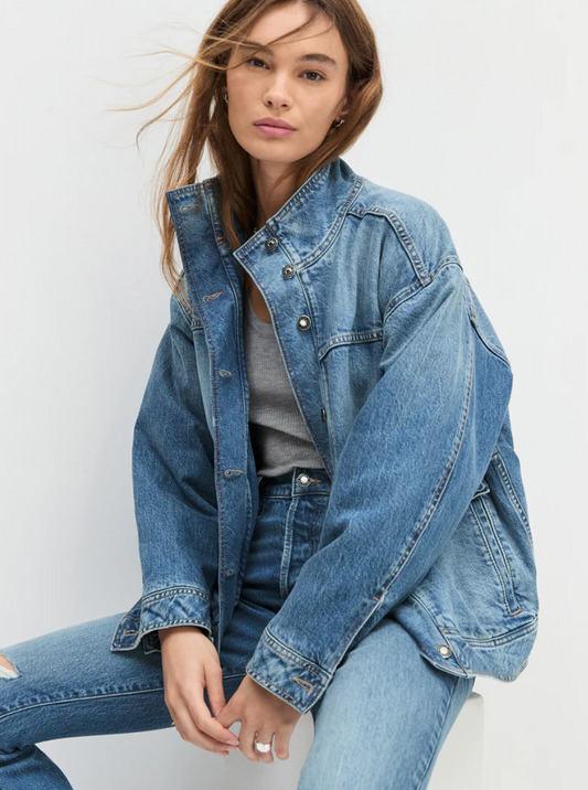 Woman wearing a denim jacket and jeans on a white background