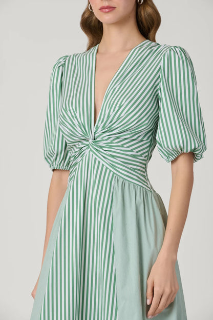 Green and white striped dress with puff sleeves on a plain background