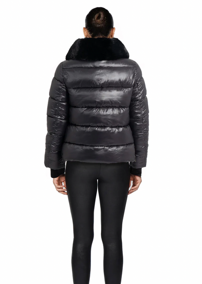 Person wearing a black puffer jacket with fur hood on a white background