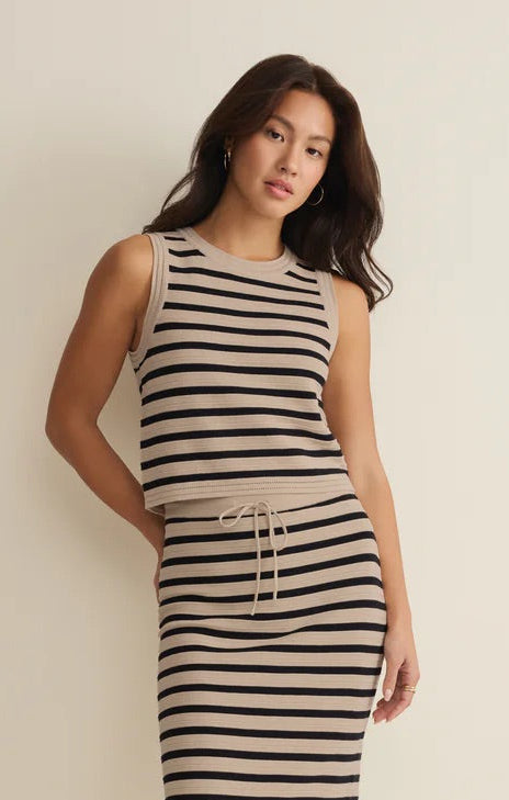 Woman wearing a black and white striped dress against a plain background